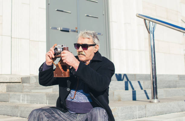 istock Senior man photographing with retro camera. 919802774