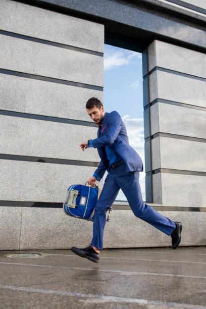 Businessman walking with luggage in business trip. Focus on man legs boarding travel arrival terminal. Business travel trip holding suitcase at airport. Young business man traveller concept