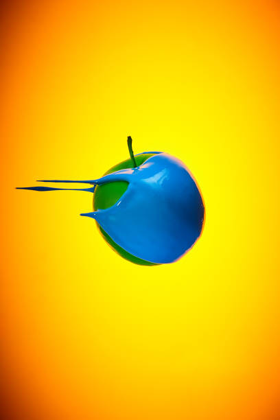 Green Apple with bpaint dripping on red background