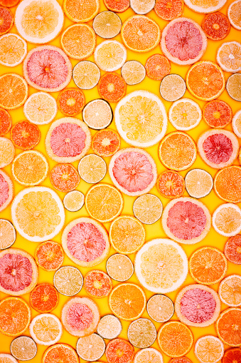 Full frame wallpaper of grapefruit, lime, lemon, and orange slices.