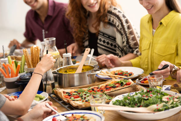 Italian dinner meeting Close-up of italian dinner meeting at table with salad and pizza mediterranean culture stock pictures, royalty-free photos & images