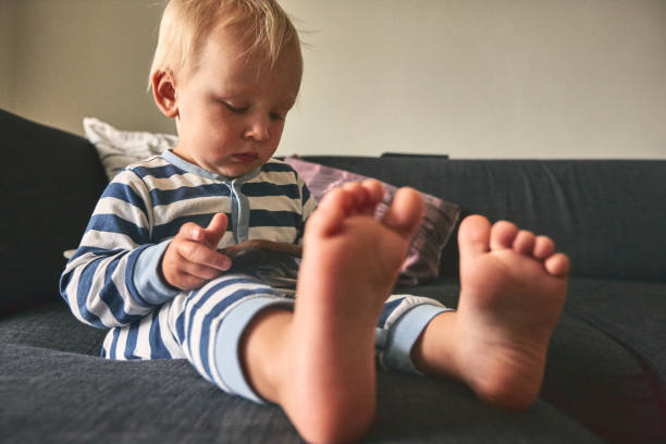 istock Cute little boy sitting on sofa with mobile phone 919828936