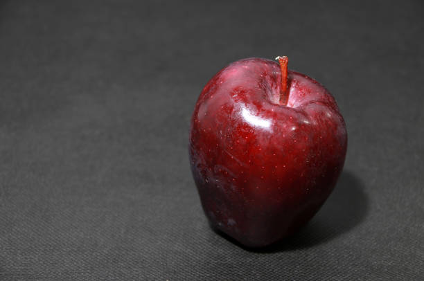 istock Dark red apple on the black floor 919832968