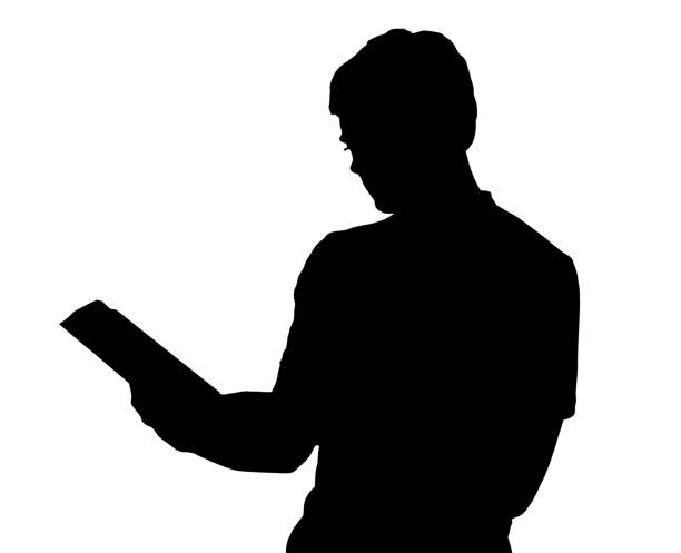 istock Profile portrait silhouette of standing teenage boy reading book 919834256
