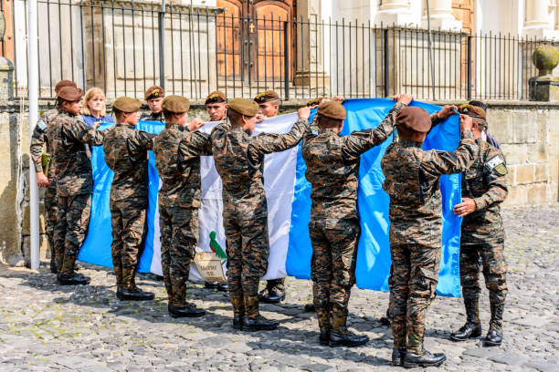 Soldiers fold Guatemalan flag alongside Mayor of Antigua after lowering it from the flagpole outside cathedral on Guatemala's Independence Day.