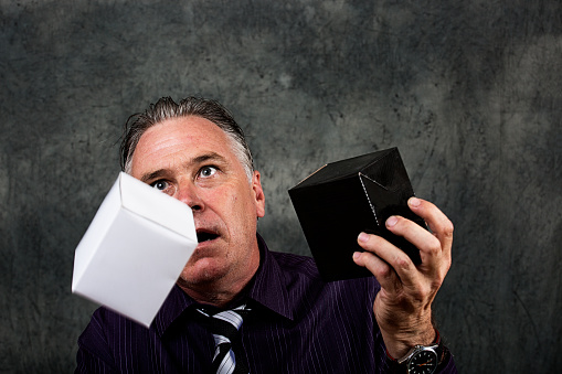 Man holding a black box and a white box