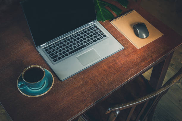 Workplace with open laptop on wooden desk for remote work in rustic style. Copy space.