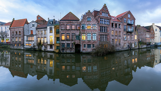 Ghent, Belgium - February 2018: Picturesque medieval buildings overlooking the Graslei harbor on Leie river in Ghent town, Belgium, Europe.