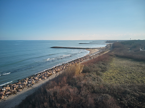 Aerial view of a portion of the beach of Rosolina Mare in Veneto (Italy) taken from a drone. In the picture you can see the various dams of rocks and the shape of the beach until perderso with the sea in the horizon.