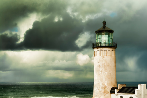 Heavy clouds from stormy skies hang over the ocean while the ever present North Head Lighthouse stands in the foreground.