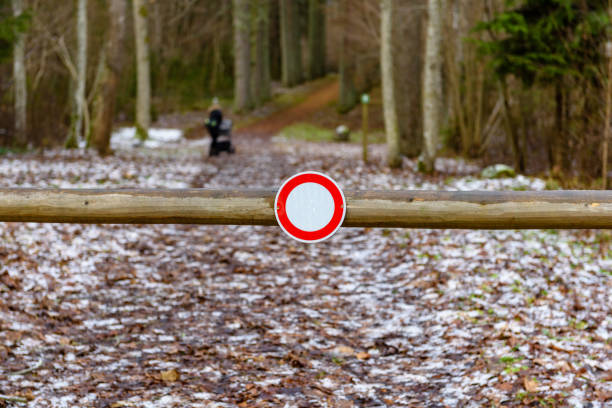 winter rural scene with closed road and stop sign in forest