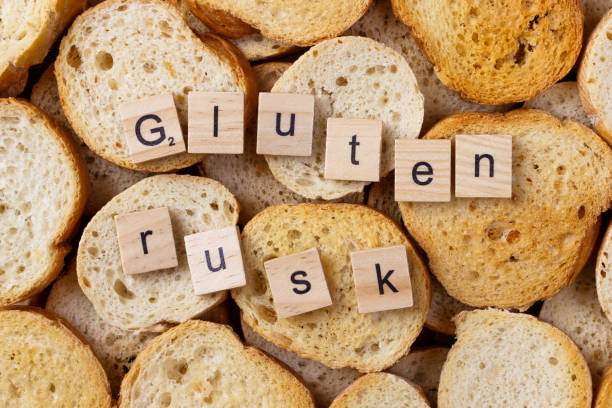 istock gluten rusk text on Background from many small round rusks. Top view 919905542
