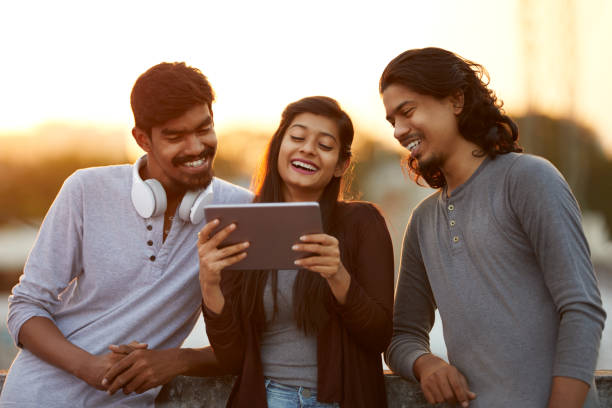 istock Cheerful young friends playing in digital tablet 919910902