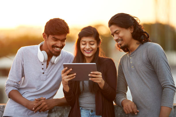 istock Cheerful young friends playing in digital tablet 919910906
