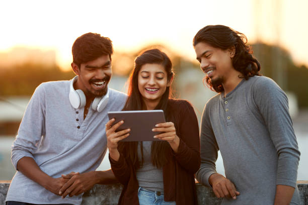 istock Cheerful young friends playing in digital tablet 919910910
