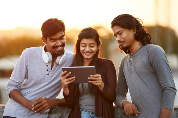 istock Cheerful young friends playing in digital tablet 919910916