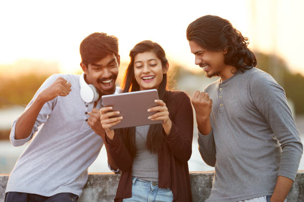 emocionado de amigos viendo la televisión desde tablet - cultura hindú fotografías e imágenes de stock
