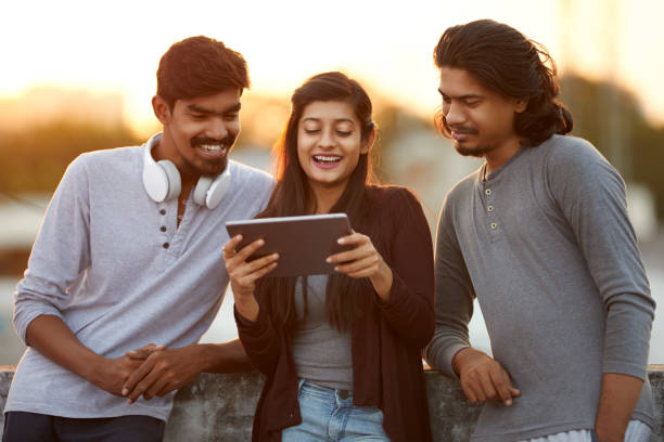 istock Cheerful young friends playing in digital tablet 919910930