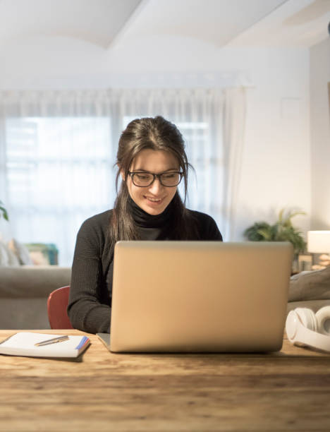 istock Young woman using laptop computer at home 919918884