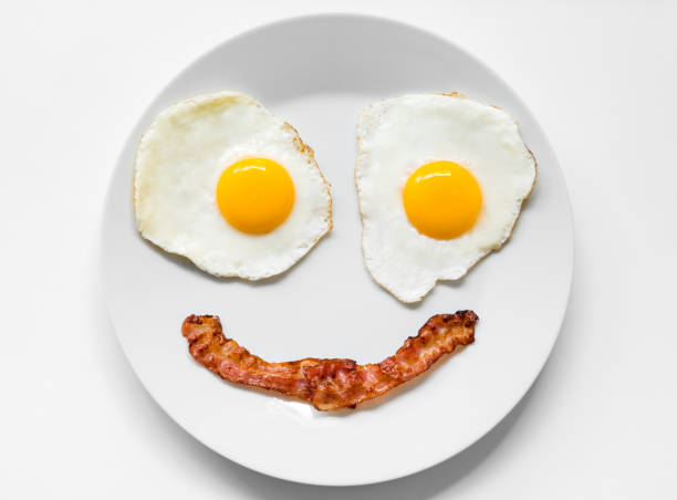 미소와 긍정적인 얼굴 튀긴 계란과 접시에 베이컨에서 만든 - eggs breakfast bacon fried egg 뉴스 사진 이미지