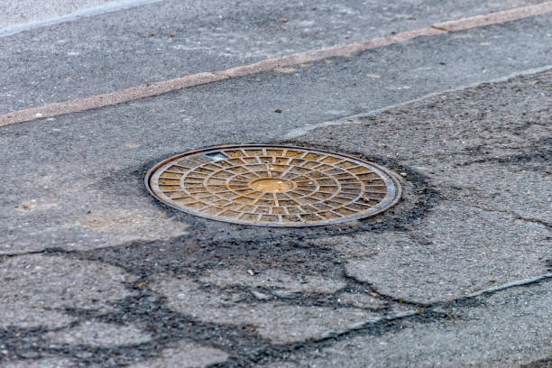 istock Manhole cover in the middle on a footpath 919919584
