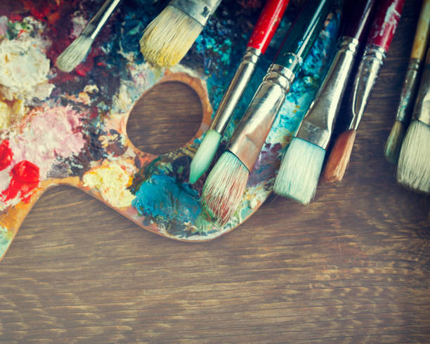 istock Artist paint brushes and palette on wooden background. 919960088