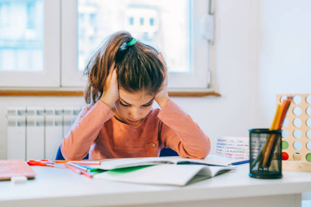 little girl scared from her homework - child thinking writing little girls imagens e fotografias de stock