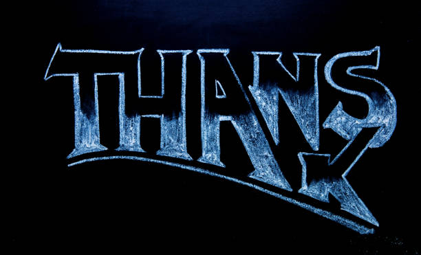 Thanks lettering by white chalk on black chalkboard. Thanks word on blackboard.