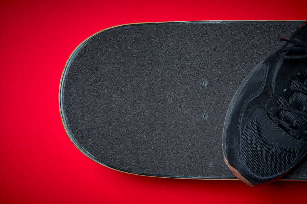 istock shoes and used skateboard on a red background 919963596