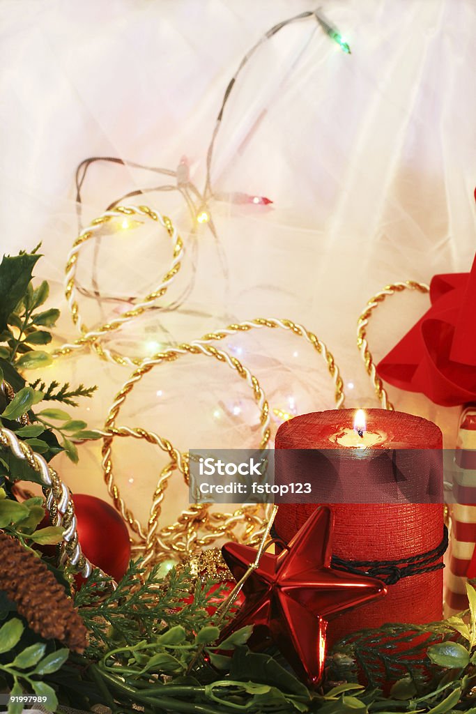 Christmas Candle Display Lovely display of red Christmas cnadle with garland, ornaments, trim and lights, off-white netting in background gives room for copy. Backgrounds Stock Photo