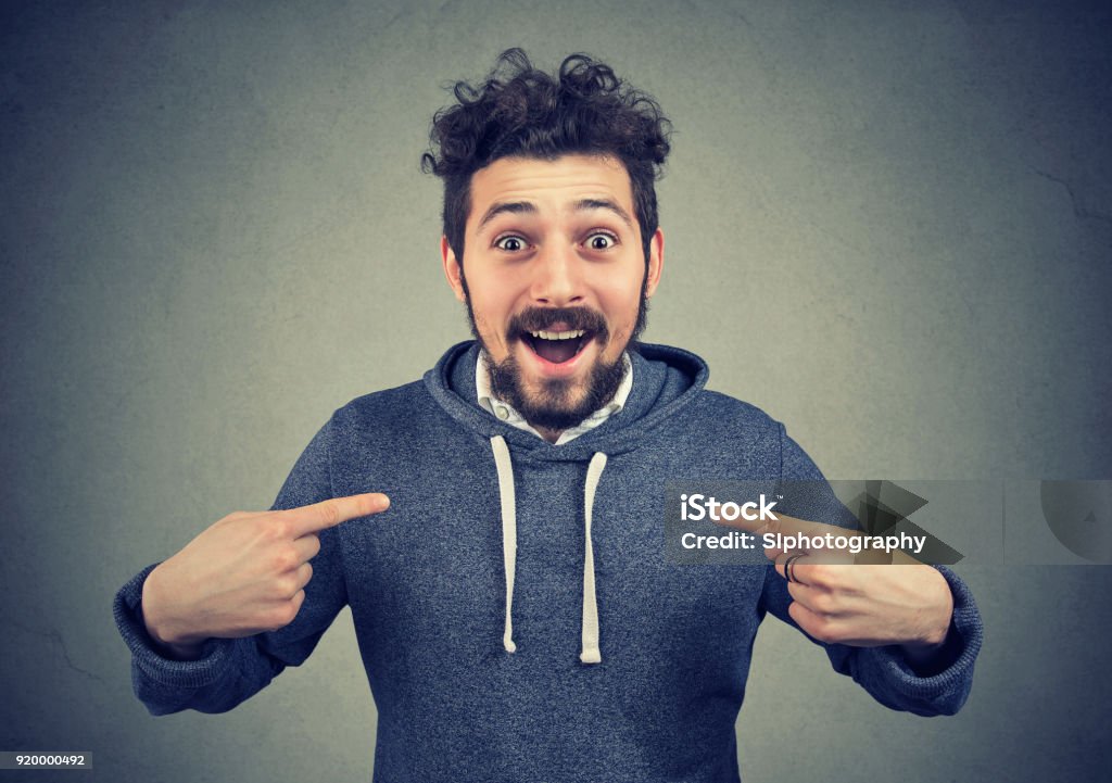Excited hipster pointing at himself in astonishment Excited young man pointing at himself in disbelief of being winner looking at camera. One Man Only Stock Photo