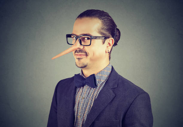 Man with long nose isolated on gray background. Liar concept. Business man with long nose isolated on gray background. Liar concept. Human emotions, feelings. falsehood stock pictures, royalty-free photos & images