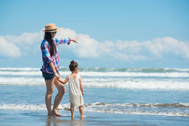 istock Mother and daughter playing on the beach 920001486