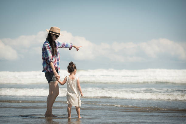 istock Mother and daughter playing on the beach 920001528