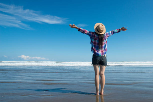 ビーチで両手を上げている女性 - sea life ストックフォトと画像