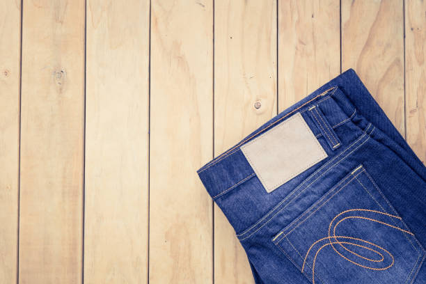 istock Blue jeans on wooden background top view 920008204