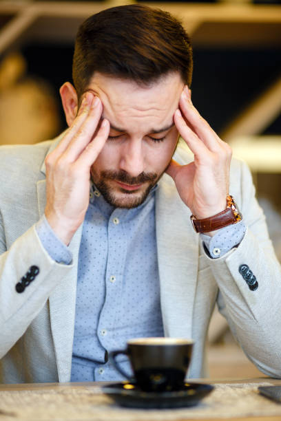istock Businessman having a headache in a cafe. 920008362