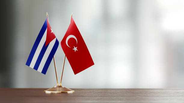 istock Cuban And Turkish Flag Pair On A Desk Over Defocused Background 920010870