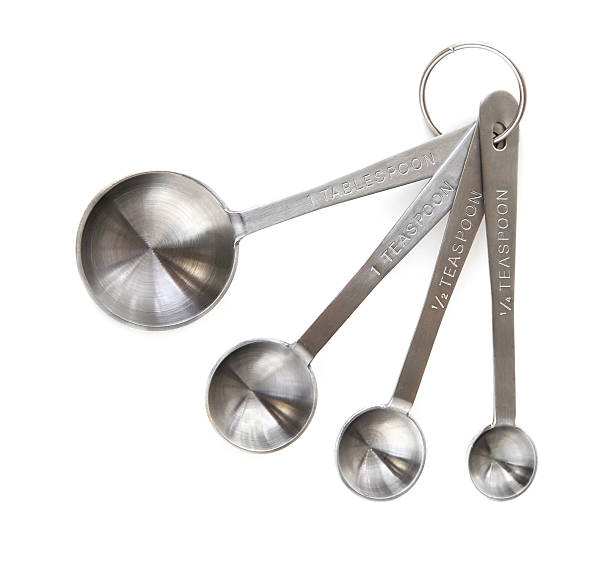 Four different size silver measuring spoons stock photo