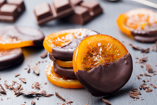 Candied orange slices in chocolate. Slate background.
