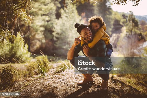 istock Father and son having fun with piggyback ride in forest 920038046