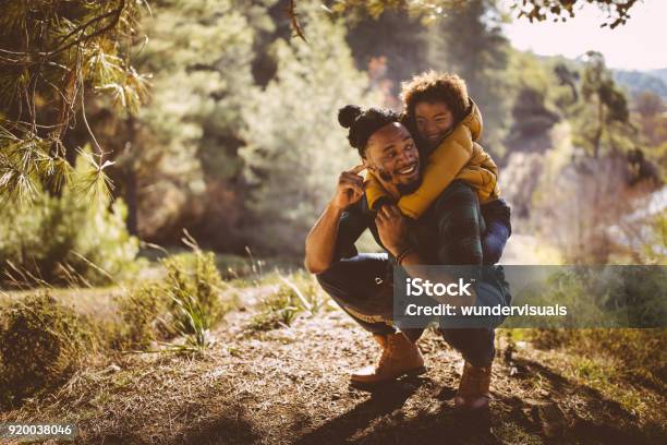 Father And Son Having Fun With Piggyback Ride In Forest Stock Photo - Download Image Now