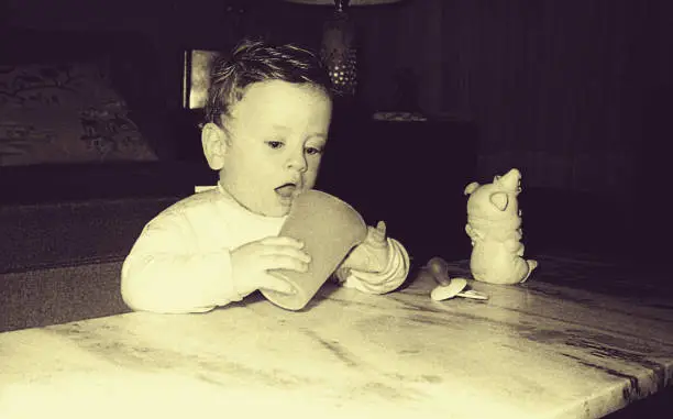 Vintage black and white  image of a baby boy standing and discovering new things