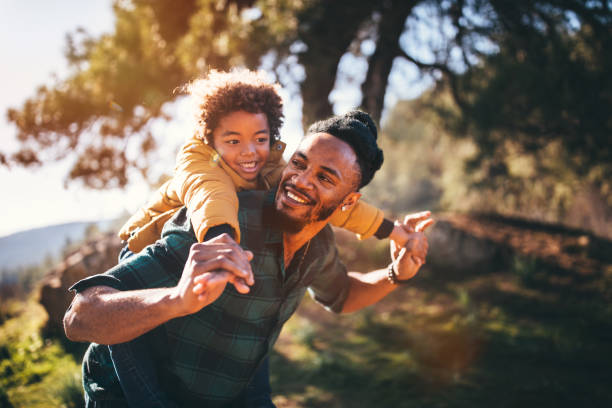 istock Father and son having fun with piggyback ride in nature 920040544