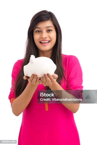 Cheerful Young Woman Saves Money In Piggy Bank Stock Photo - Download Image Now - 2015, Adult, Adults Only