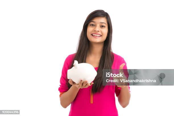 Cheerful Young Woman Saves Money In Piggy Bank Stock Photo - Download Image Now - Savings, India, Only Women