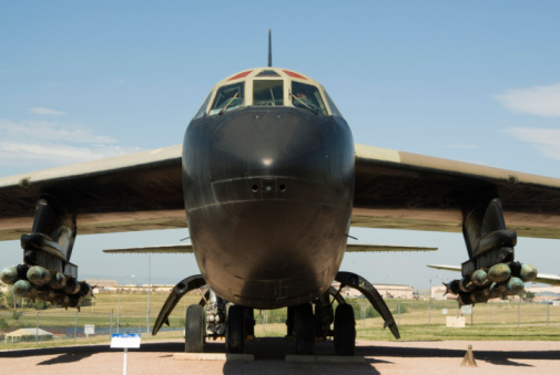 Military figher airplane landing on an airport runway.