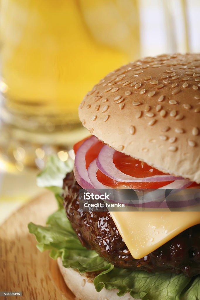 Classico cheeseburger con birra su sfondo - Foto stock royalty-free di Alimentazione non salutare