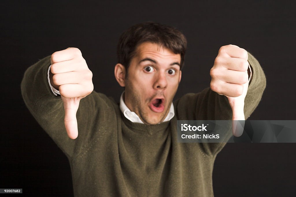 A man putting his thumbs down in a disapproving manner Businessman giving two thumbs down. Customer Stock Photo
