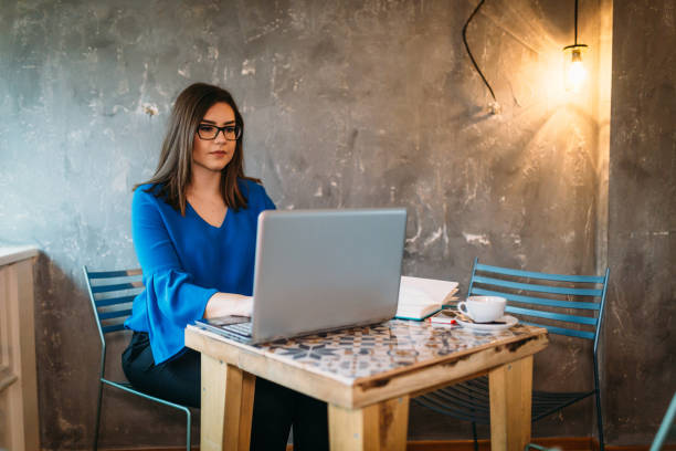 istock Young woman using laptop and working from the coffee bar during a day 920080418